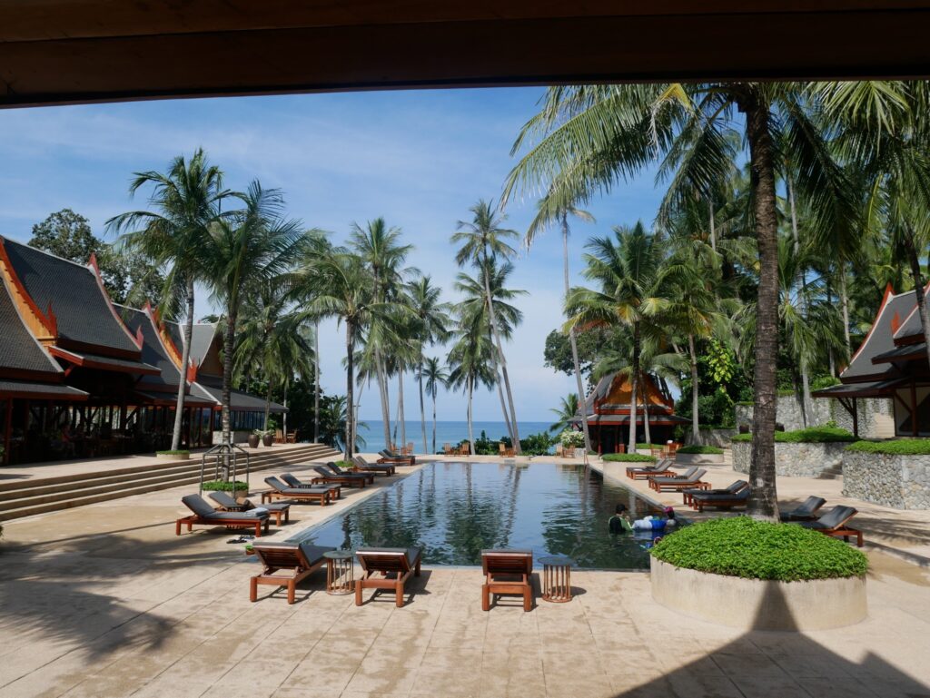 Urlaubsresort mit Palmen und Pool am Meer in Thailand