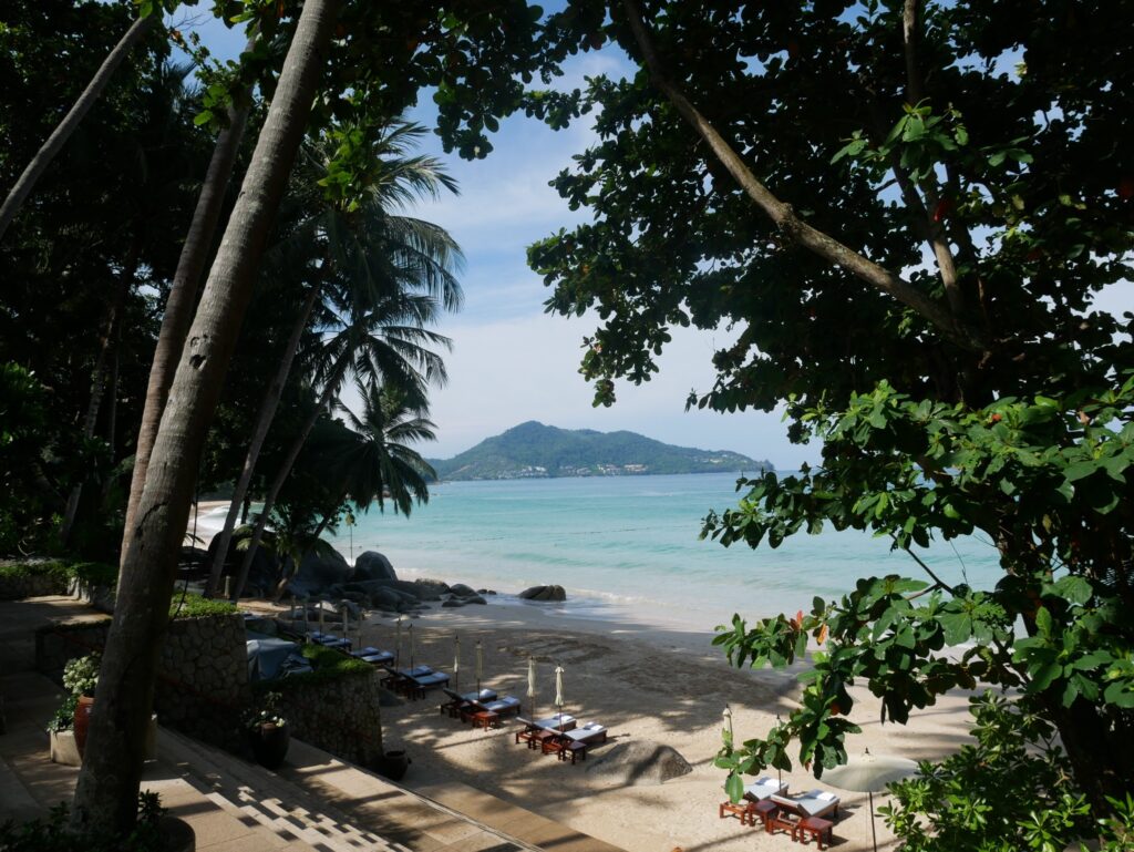 Strand und Meer in Phuket von einem Hang aus Bäumen heraus betrachtet
